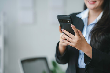 Businesswoman happily using smartphone in office, staying connected and productive in corporate world, smiling face navigating digital realm