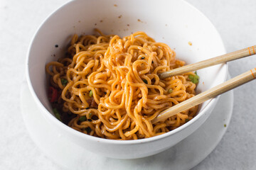 Overhead view of Spicy instant noodles with slices of green and red chili, spicy ramen noodles in a...