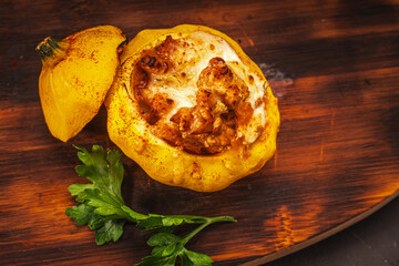Small yellow pumpkins stuffed on a wooden board on a dark gray table. Autumn dish for Halloween. Copy space