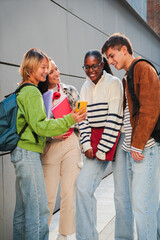 Vertical Group of teenage students talking on the university campus after classes. Young classmates...
