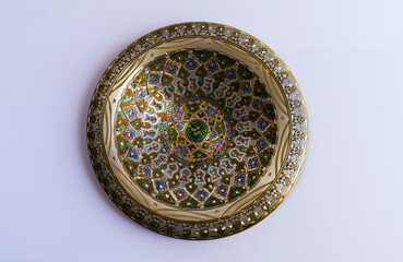 decorative copper plate with colorful pattern on white background.