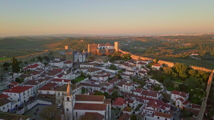 Obraz premium Aerial twilight medieval castle Obidos and Portugal village. Sunset at rooftops