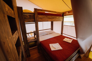 Interior of cozy open glamping tent. Camping tent for outdoor summer holiday and vacation