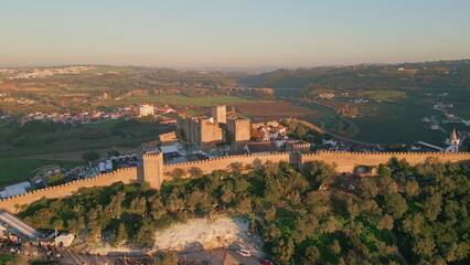 Obraz premium Aerial medieval fortress stretching at nature greenery at evening light. 