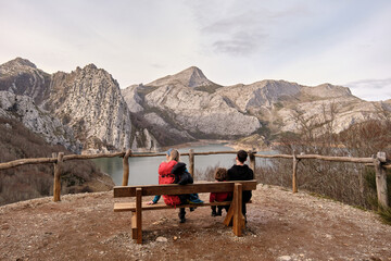 Hiking family sitting on a bench admiring the mountains