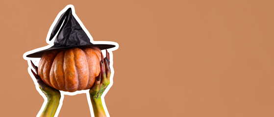Witch holding pumpkin with hat on beige background. Halloween celebration