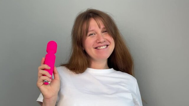 Happy young woman with sex toy for adults, female with vibrator 