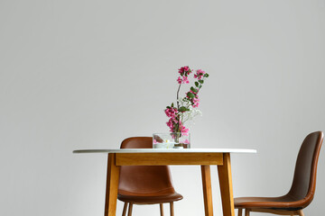 Beautiful ikebana on dining table in light room