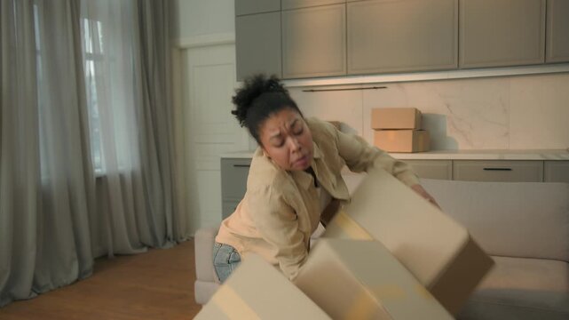 Female homeowner African American woman tenant moving in new home relocation carry cardboard deliver parcels tired courier drop boxes crash failure shopping delivery disappointed upset girl in kitchen