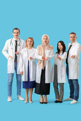 Professional team of doctors with red ribbons on blue background. World AIDS Day concept