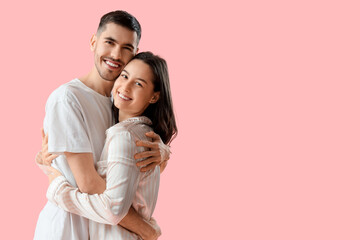 Happy young couple on pink background