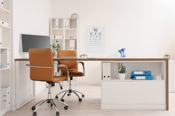 Interior of medical office with doctor's workplace and eye test chart