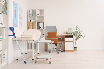 Interior of medical office with massage therapist's workplace and couch