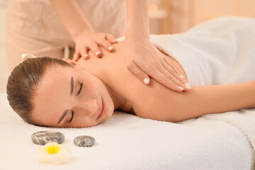 Beautiful young woman undergoing treatment by therapist in spa salon