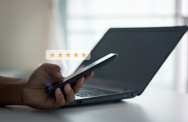 Customer experience concept. Product or service review ideas from customer. Client using smartphone to submit five star review rating for online satisfaction survey. Positive feedback on mobile phone.