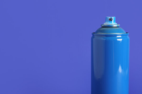 Spray paint can on blue background