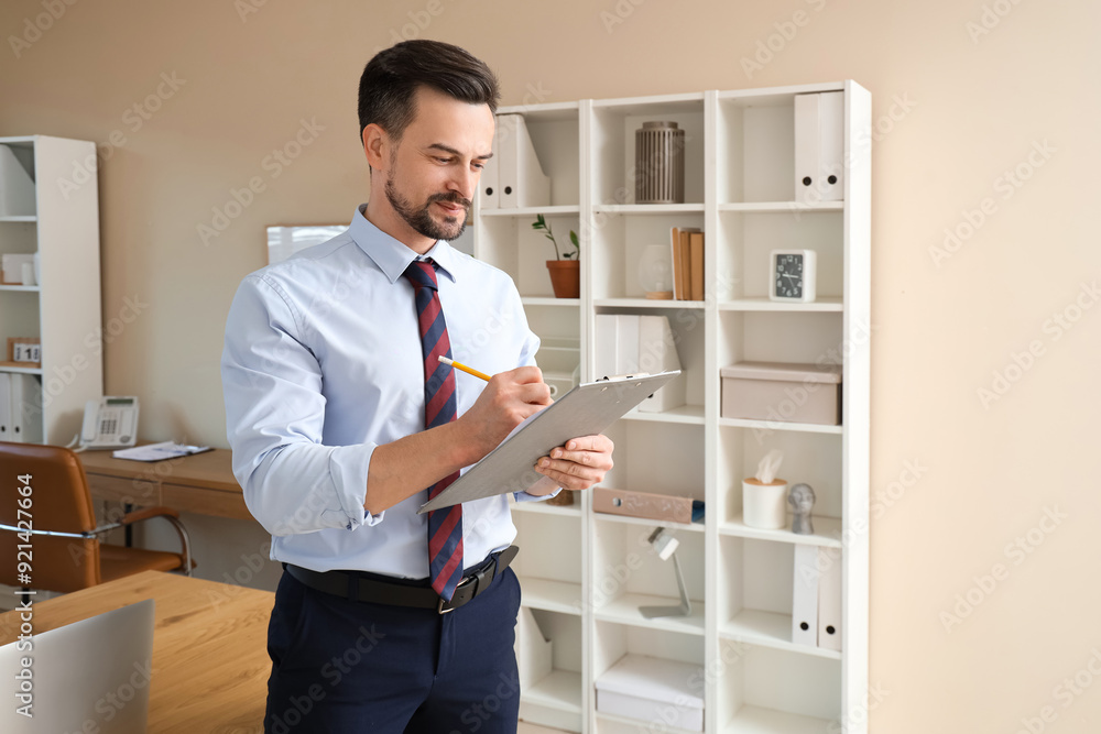 Poster male accountant writing on clipboard in office