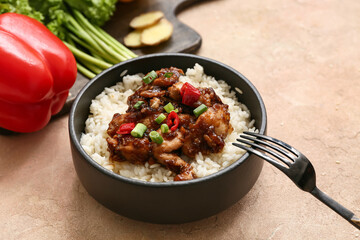 Tasty sweet and sour chicken with rice in bowl and fork on beige grunge background, closeup