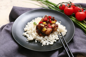 Tasty sweet and sour chicken with rice in plate, napkin and chopsticks, closeup