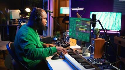 Talented musician mixing and mastering songs on a console, twisting pre amp knobs to add sound...