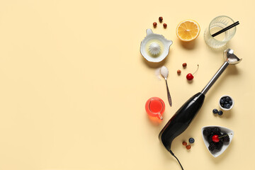 Blender, berries, jug of juice and lemon on beige background
