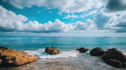 Obraz premium Sea with rocks under a blue cloudy sky