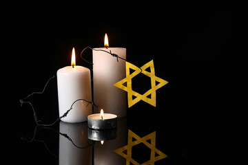 Burning candles, barbed wire and Star of David on dark background. International Holocaust...