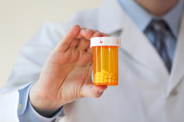 Healthcare professional holding a bottle of prescription pills