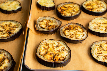 Baked Eggplant Slices on a Sheet Pan: Sliced and baked eggplant on a sheet pan lined with unbleached parchment baking paper