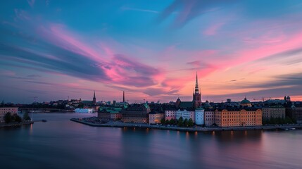 Riddarholmen church tower in the stockholm cityscape at sunset with vibrant clouds reflected in the water