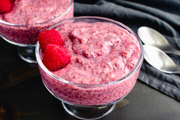 Dishes of Raspberry Chia Pudding Close-up: Healthy fruit and chia seed breakfast pudding garnished with fresh raspberries