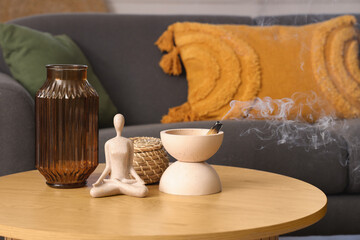 Bowl with Palo Santo, statuette and vase on table in living room, closeup