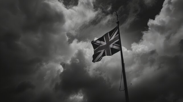 Black and white photo of the union jack flag waving on a flagpole under a dramatic cloudy sky - Powered by Adobe