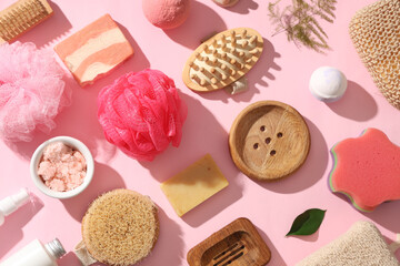 Composition with cosmetic products and different bath supplies on pink background