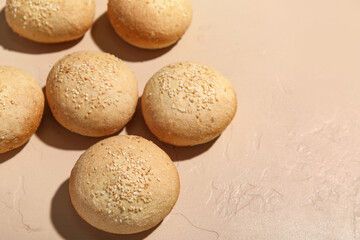 Fresh buns with sesame seeds on beige background