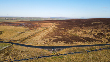 Obraz premium Yorkshire Moors in Autumn browns, quiet road and photo taken by drone. 