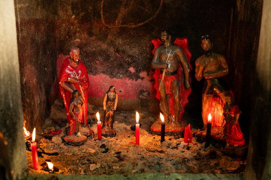 images of exu and pomba gira from brazilian umbanda with lit candles
