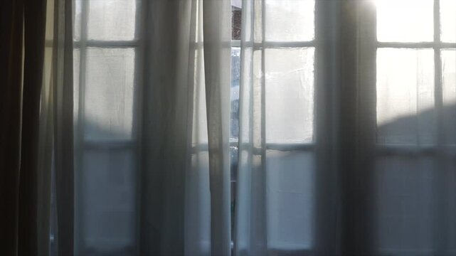 Soft light coming through sheer curtains on large bay window, flickering light