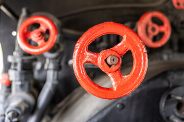 Valves and controls in a vintage steam locomotive showcasing intricate machinery from an era of steam-powered transport
