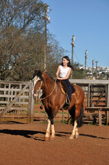 menina vaqueira cavalgando com cavalo marrom 