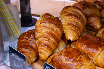 Fresh baked buttered croissants and sweet buns, pastries in village bakery in France