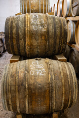 Aging process of cognac spirit in old dark French oak barrels in cellar in distillery house, Cognac...