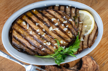 Italian style starter served in restaurant, grilled eggplant with garlic, olive oil and fresh parsley