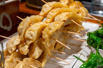 Typical snacks of Basque Country, pinchos or pinxtos skewers with small pieces of bread, fish, sea food, sweet green pepper served in bar in San-Sebastian or Bilbao, Spain