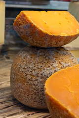 Pieces of native French aged cheese Mimolette, produced in Lille with greyish curst made by special cheese mites close up