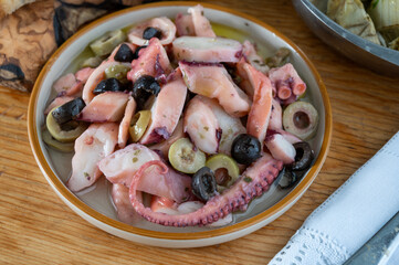 Tasty salad or starter seafood dish, grilled octopus ligurian style with green and black olives served in Italian  restaurant