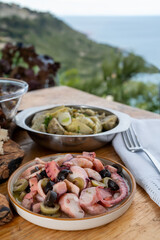 Tasty salad or starter seafood dish, grilled octopus ligurian style with green and black olives served in Italian  restaurant