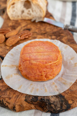 Rond des Vignes washed-rind cheese with.ivory-orange rind, strong nose with aromas, French soft cheese with orange rind