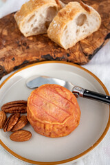Rond des Vignes washed-rind cheese with.ivory-orange rind, strong nose with aromas, French soft cheese with orange rind