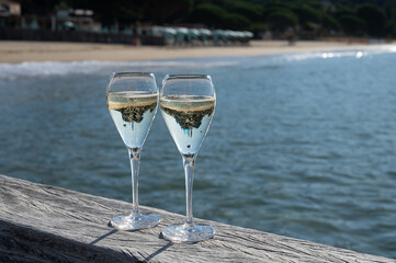 Summer time in Provence, two glasses of cold champagne cremant sparkling wine on famous Pampelonne sandy beach near Saint-Tropez in sunny day, Var department, France, beach club party